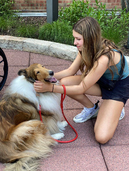 Harper greets one of the Collies she works with in Animal Assisted Therapy