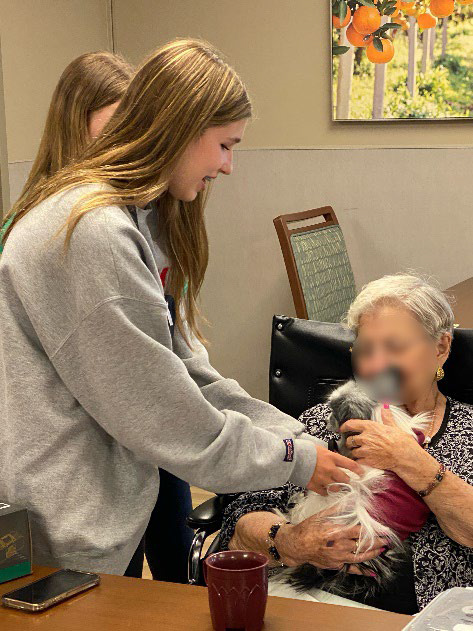 Harper and her therapy-Papillion greeting a resident